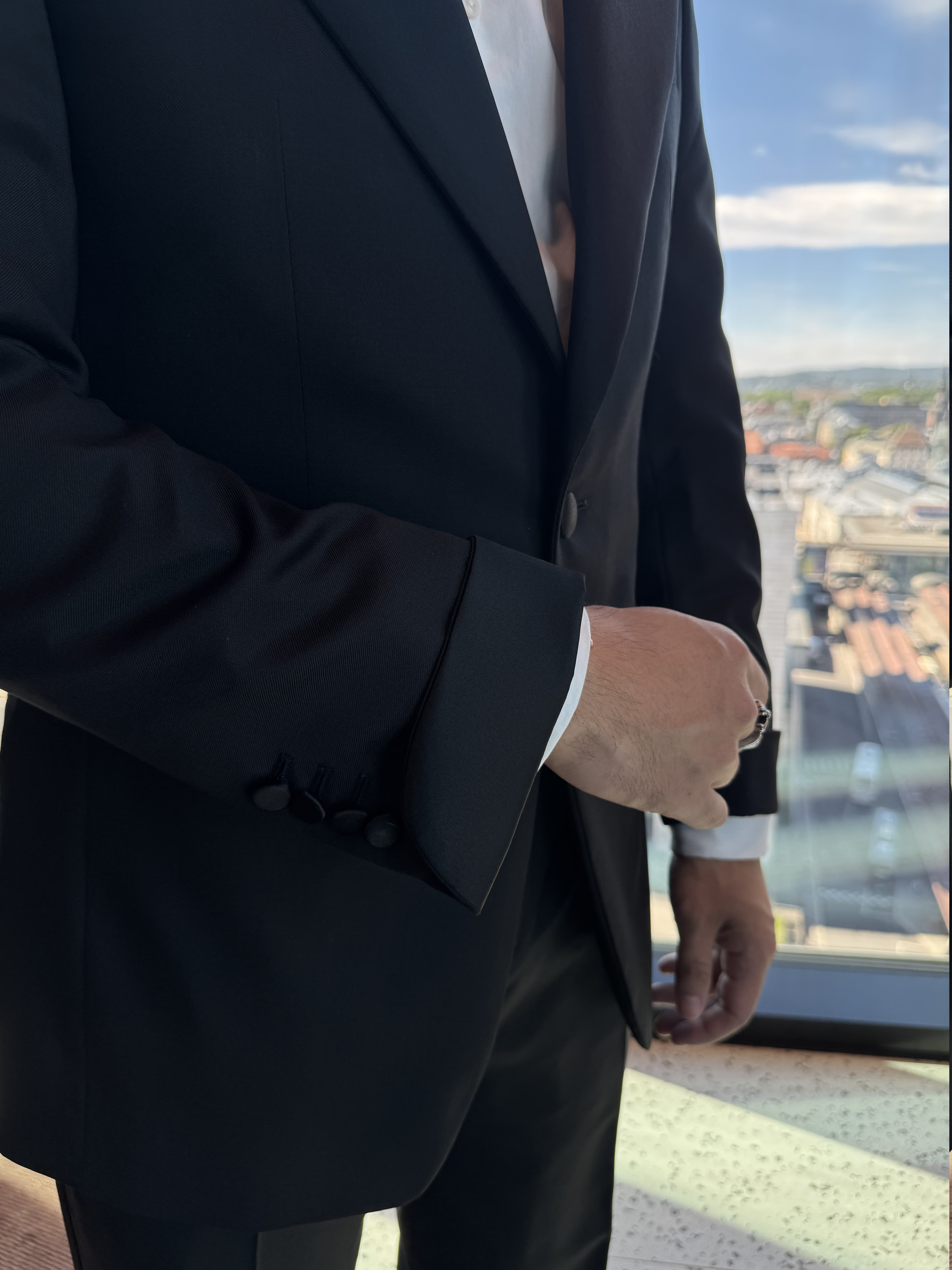 Detalj av satin mousquetaire-mansjett på enkeltspent sort smoking