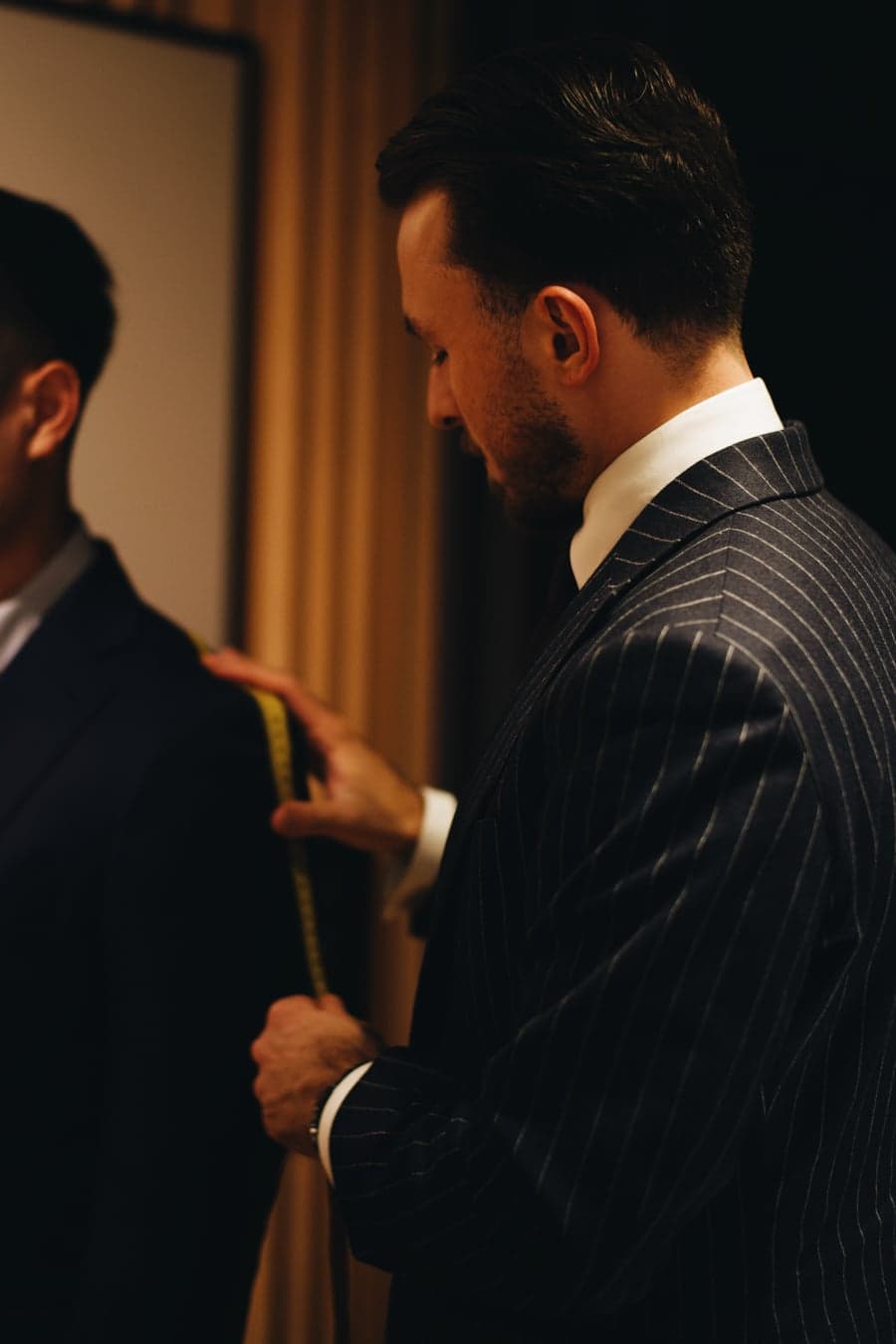 Skredder tar mål av en kunde hos Sabiro Tailoring